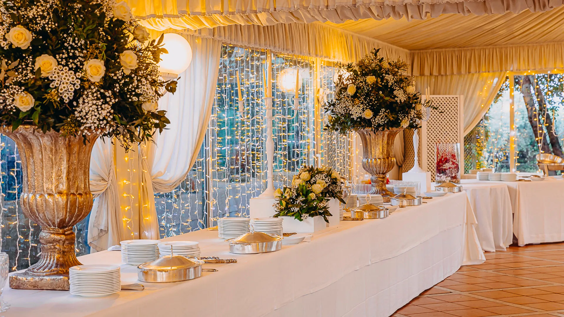 Tavolo del buffet allestito con alzate di fiori bianchi
